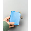 Skórzane, błękitne etui na karty w orientacji pionowej